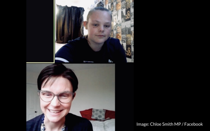 A screenshot of the Zoom call between Ruby Bishop and MP Chloe Smith. Ruby is at the top of the screen - she has blonde hair tied in a bun and is wearing a navy blue sports top. Chloe is at the bottom of the screen. She has short dark brown hair. She is wearing grey glasses, a blue top and a blue necklace.