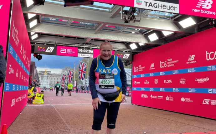 A picture of Kate at the finishing line with Buckingham Palace in the background. 